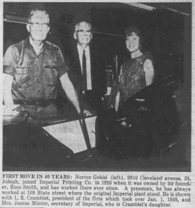 A black-and-white news clipping of three individuals. They are posing for the camera and smiling inside Imperial Publishing Company. 