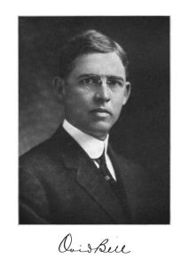 a black and white photograph of Ovid Bell. He is wearing a suit and glasses. 