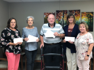 Angie Warner and coworkers holding envelopes