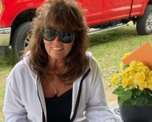 Renita Terry sitting at a picnic table with flowers