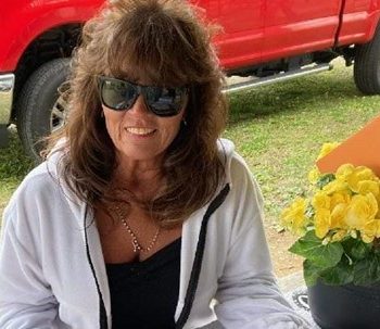 Renita Terry sitting at a picnic table with flowers