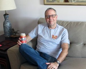 Phil Norton on couch with Duff beer can and t-shirt