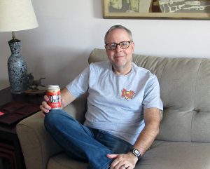 Phil Norton on couch with Duffs beer