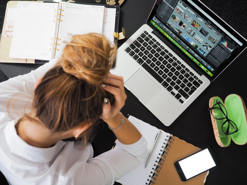 A graphic designer slumps over her computer, clearly frustrated.