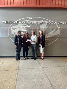Julie Newhouse presents a $2,500 check to Ripon Area School District’s Chrissy Damm, Tammy Fox and Jill Puhlmann-Becker.