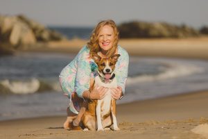 Kirsten Smith with her fur baby (dog) Samantha posing for a photo on the beach