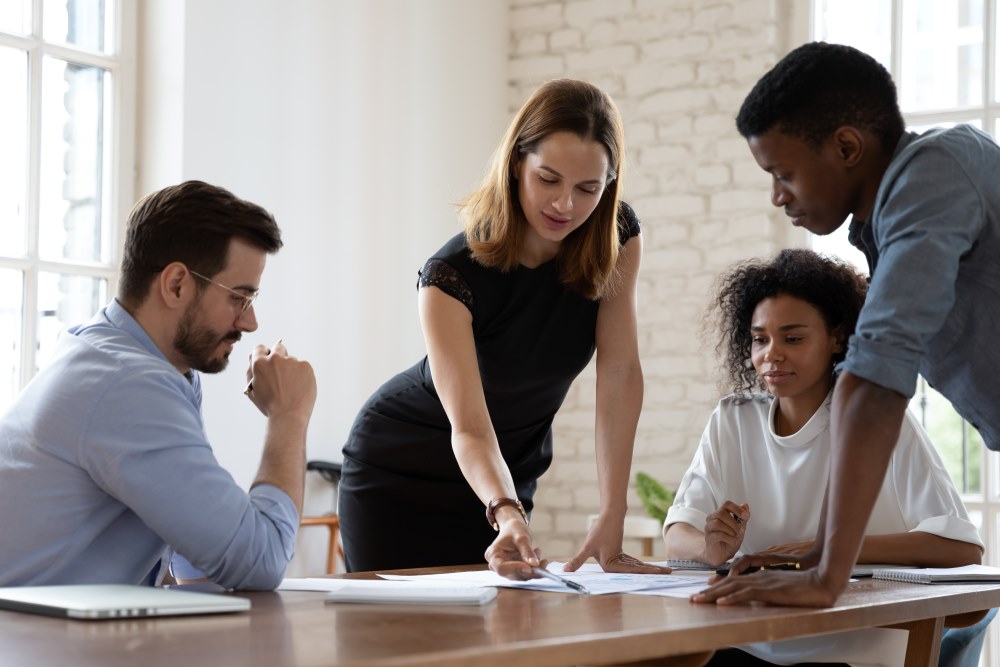 A team of young professionals gather around a table to collaborate on a project