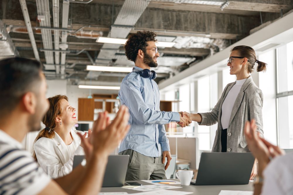 A young man shaking hands with his boss after being promoted