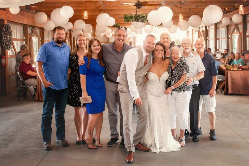 Marie Frazier with her family on her wedding day in a barn.