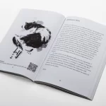 An open magazine with a hand graphic and text