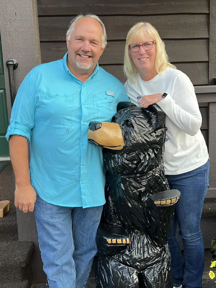 Laruie Sasada and her husband next to a black bear statue