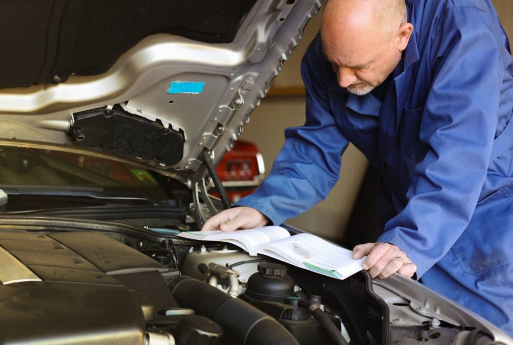 A mechanic reading a service manual