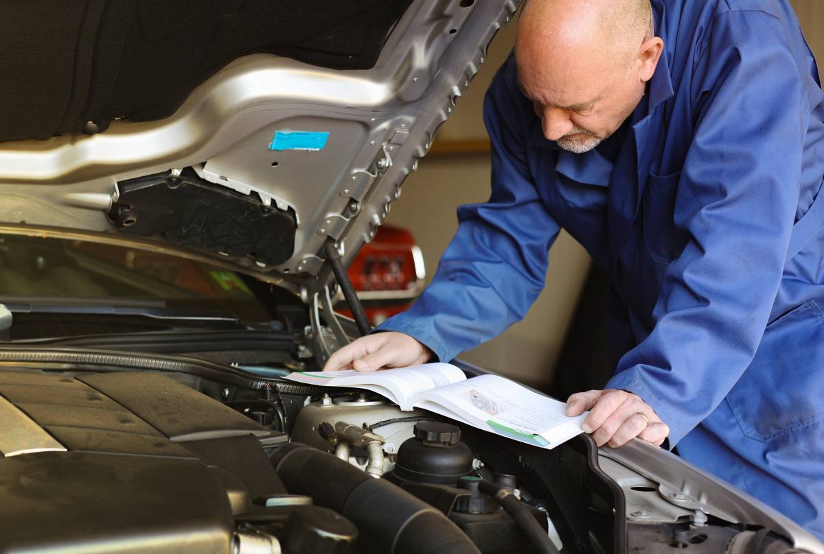A mechanic reading a service manual