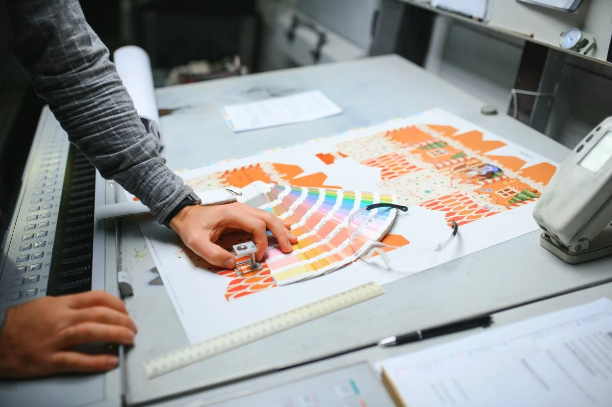 A worker examining a color print proof