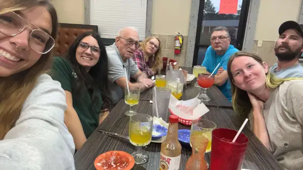 David with family and friends at a restaurant table.