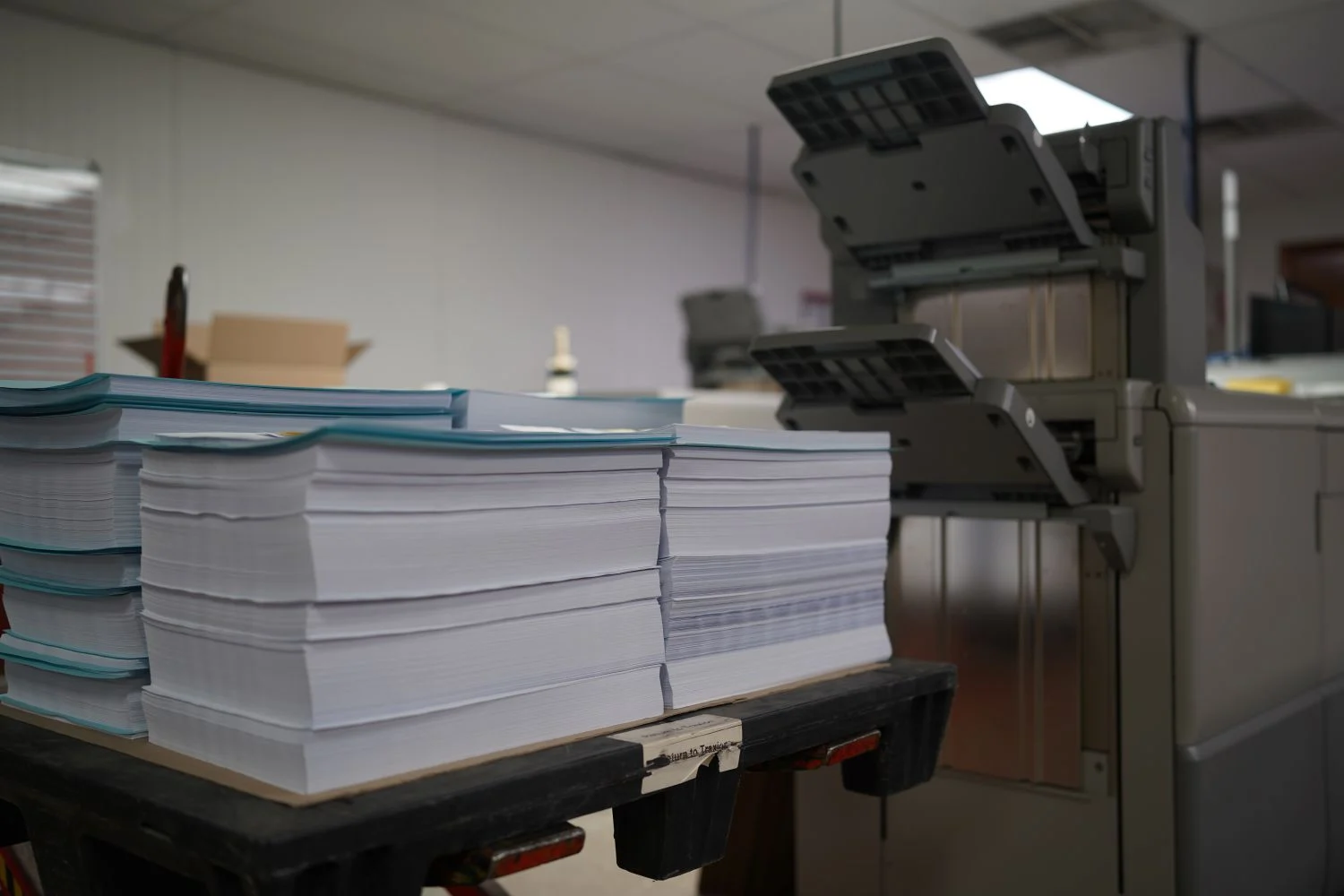 Unbound paper sitting next to a digital printer