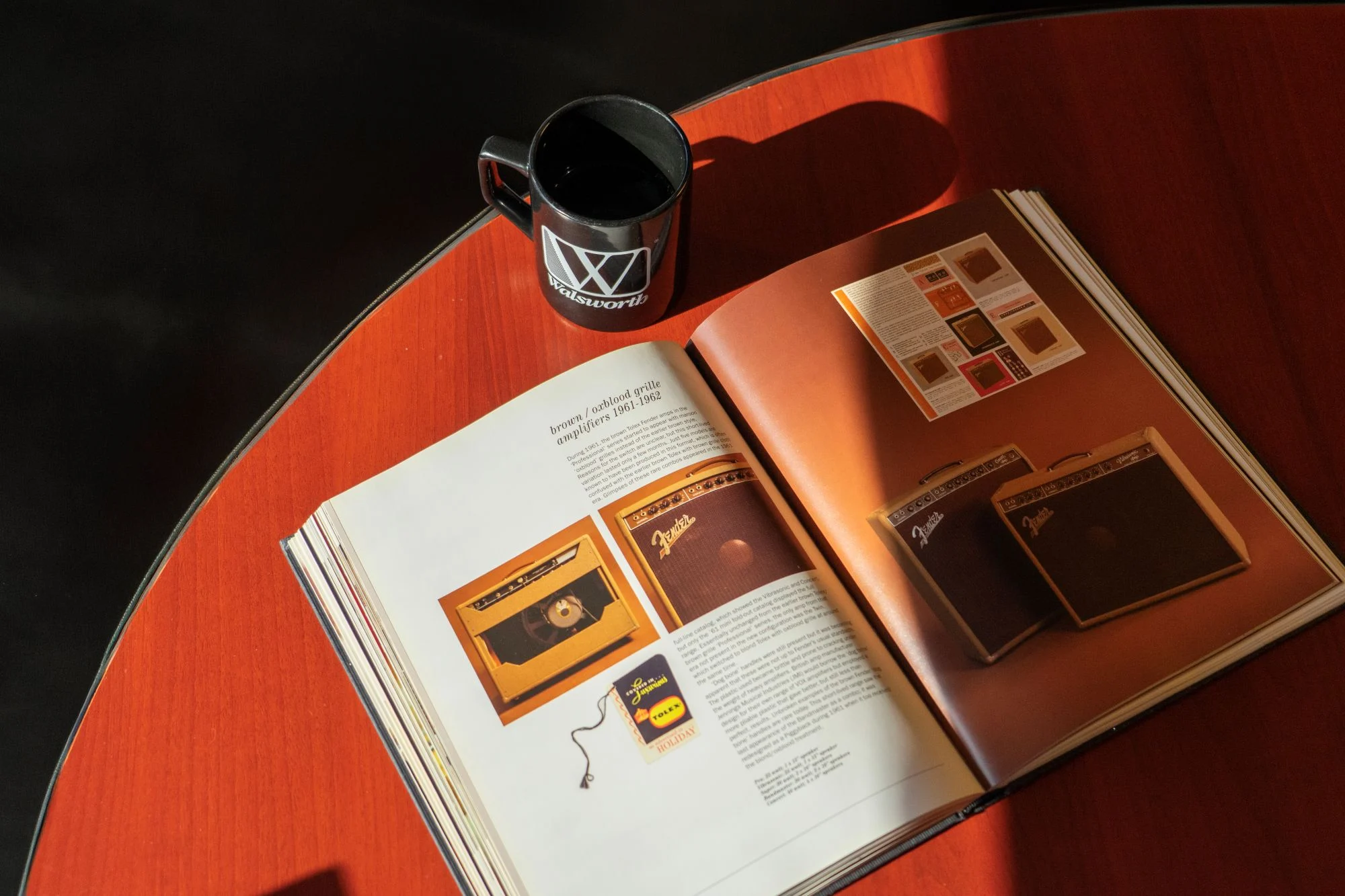 A coffee table open next to a Walsworth coffee mug