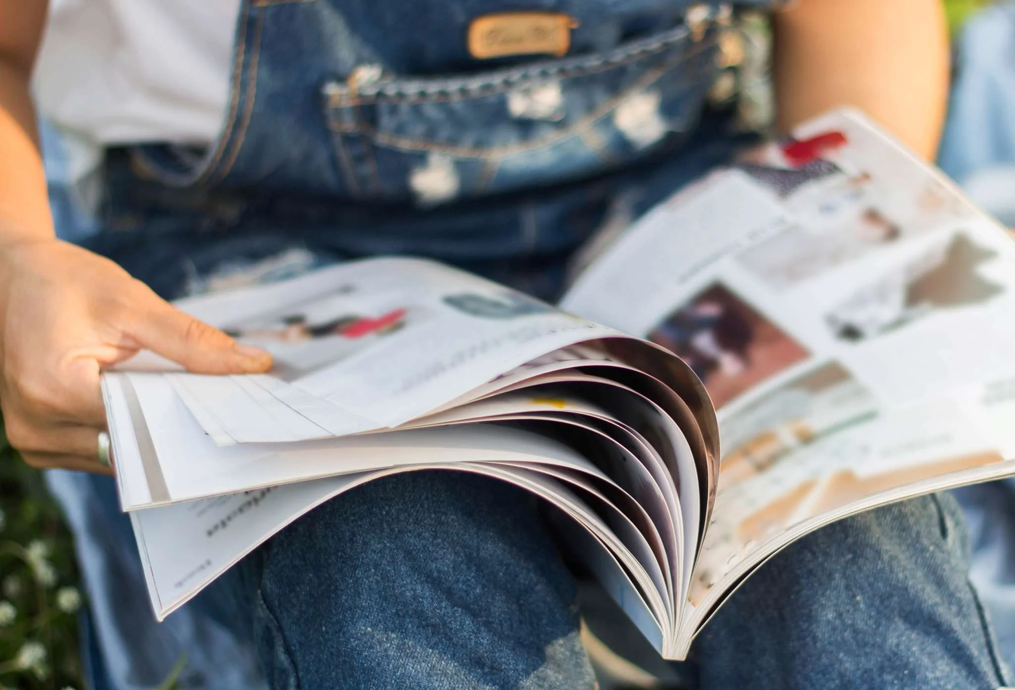 A man in overalls reading a magazine
