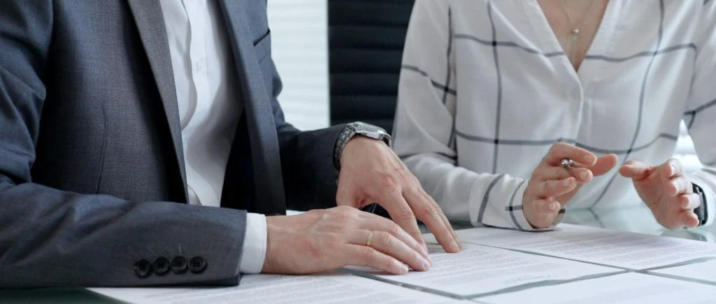 A man and a woman sit at a table to discuss business