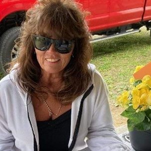 Renita Terry sitting at a picnic table with flowers